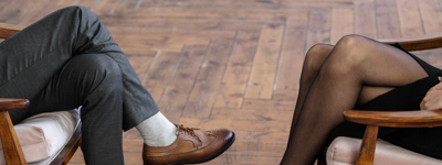 Two people sitting opposite each other crossed legged.
